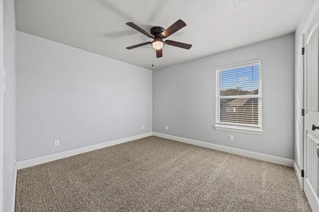 a view of an empty room with a ceiling fan