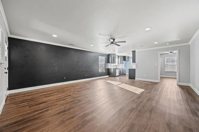 a view of empty room with wooden floor and window