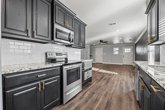 a kitchen with stainless steel appliances granite countertop a stove and a sink