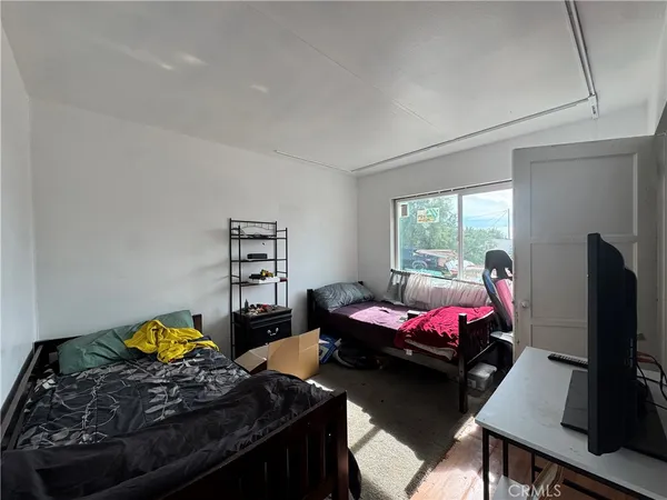 a bedroom with furniture and a flat screen tv