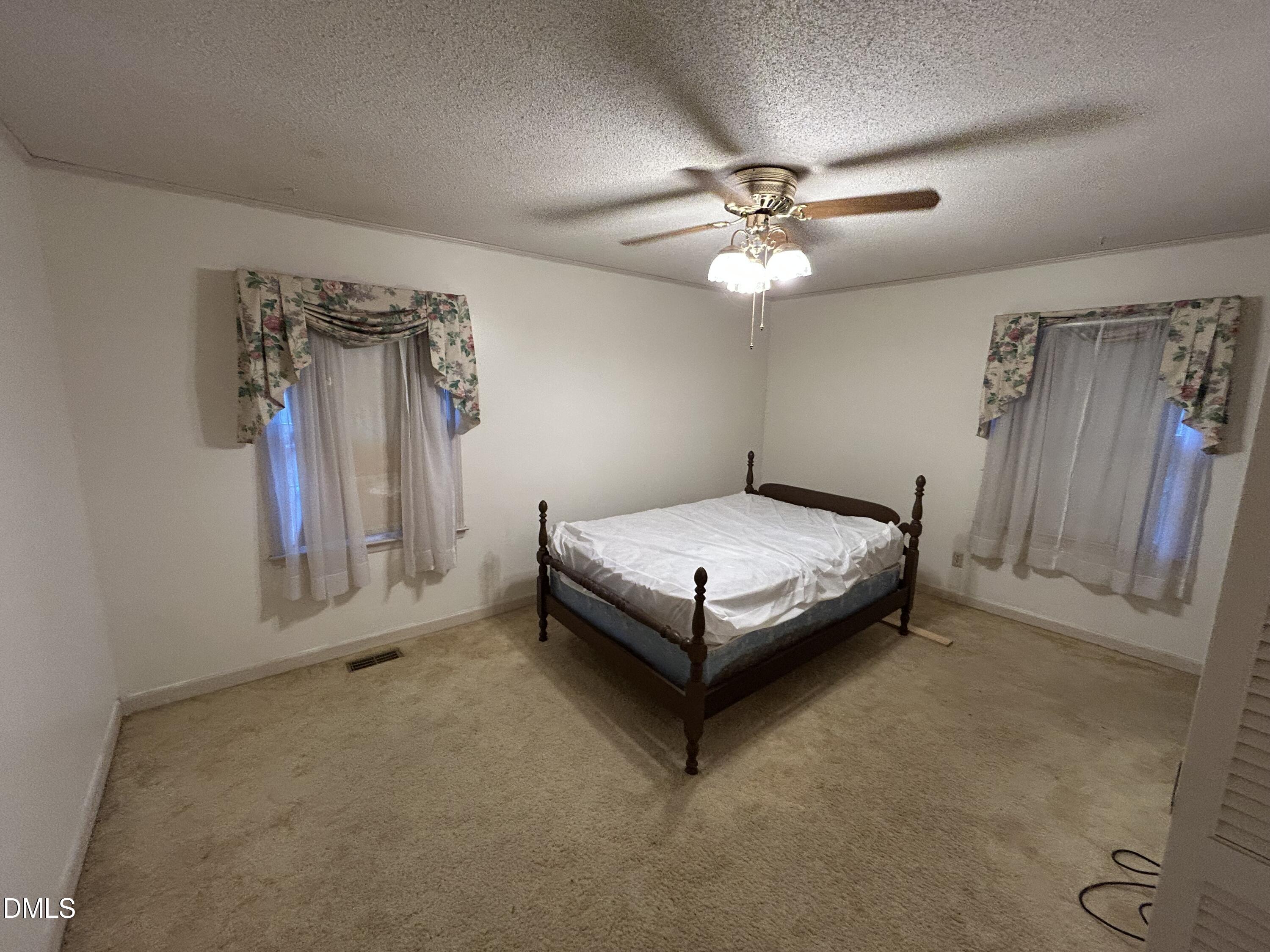 2912 Oxford Road Henderson, NC 27536 - Photo 18 of 25 a bedroom with a bed and a chandelier