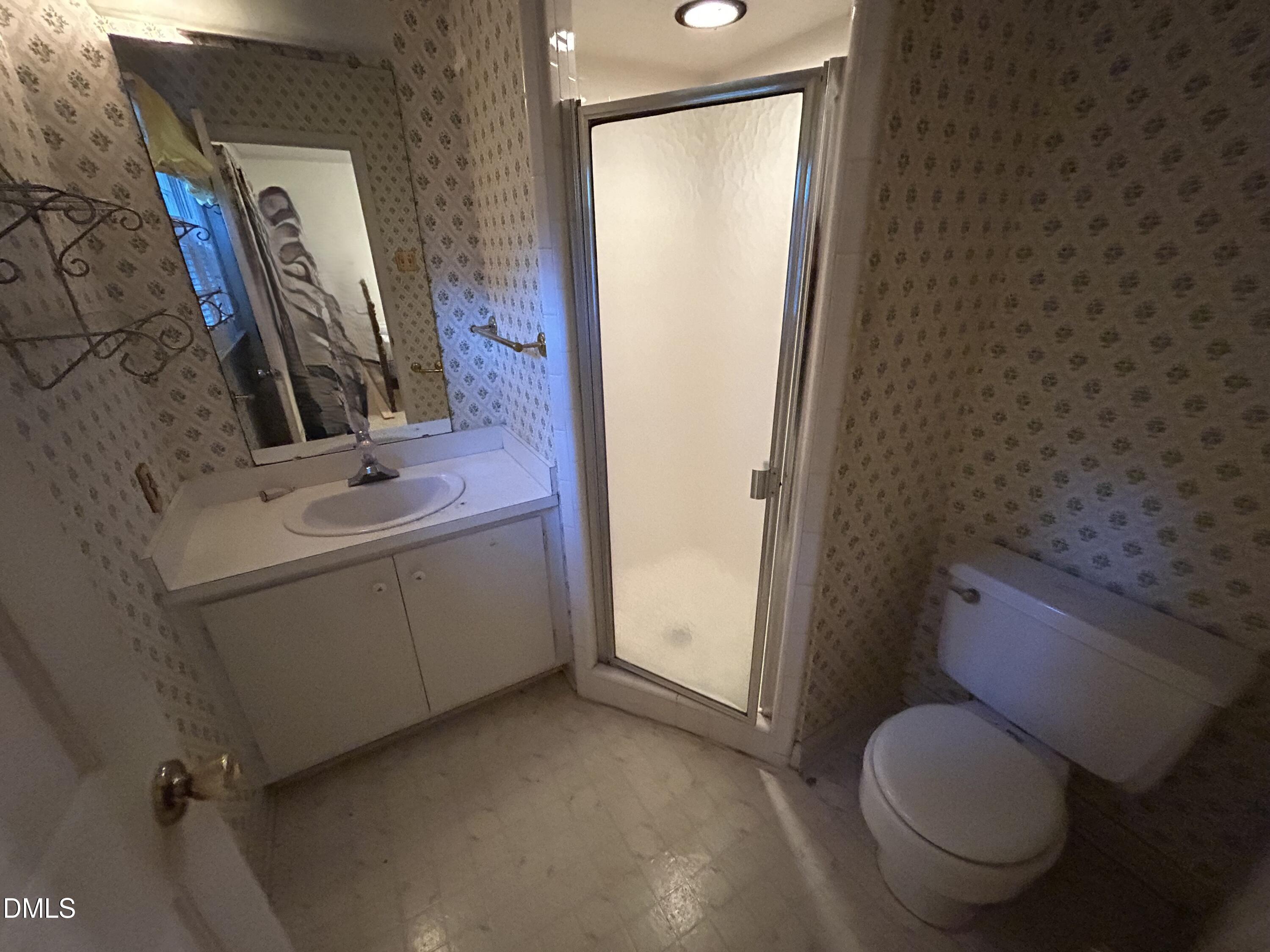 2912 Oxford Road Henderson, NC 27536 - Photo 19 of 25 a bathroom with a toilet sink and mirror