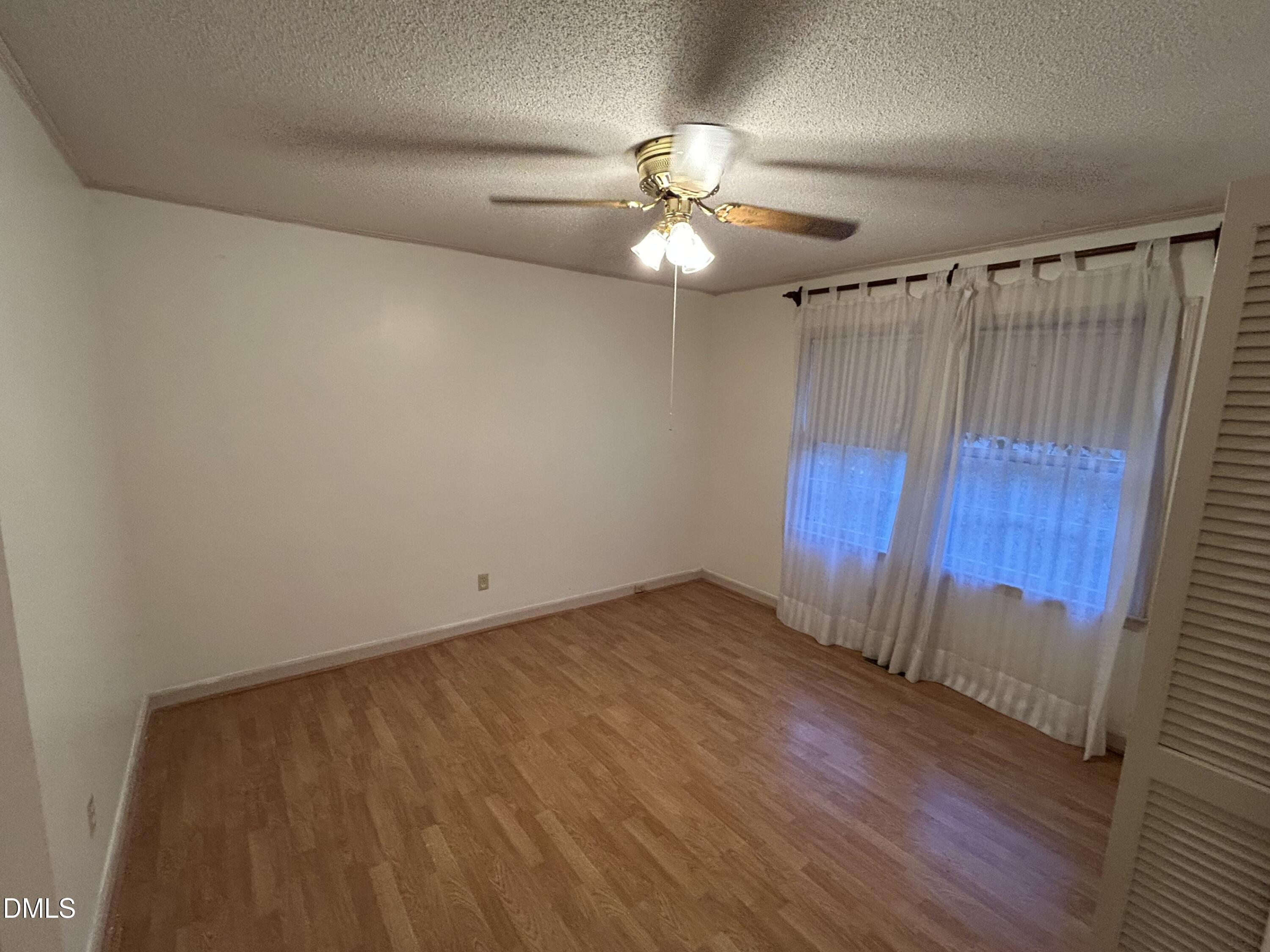 2912 Oxford Road Henderson, NC 27536 - Photo 22 of 25 an empty room with wooden floor fan and windows