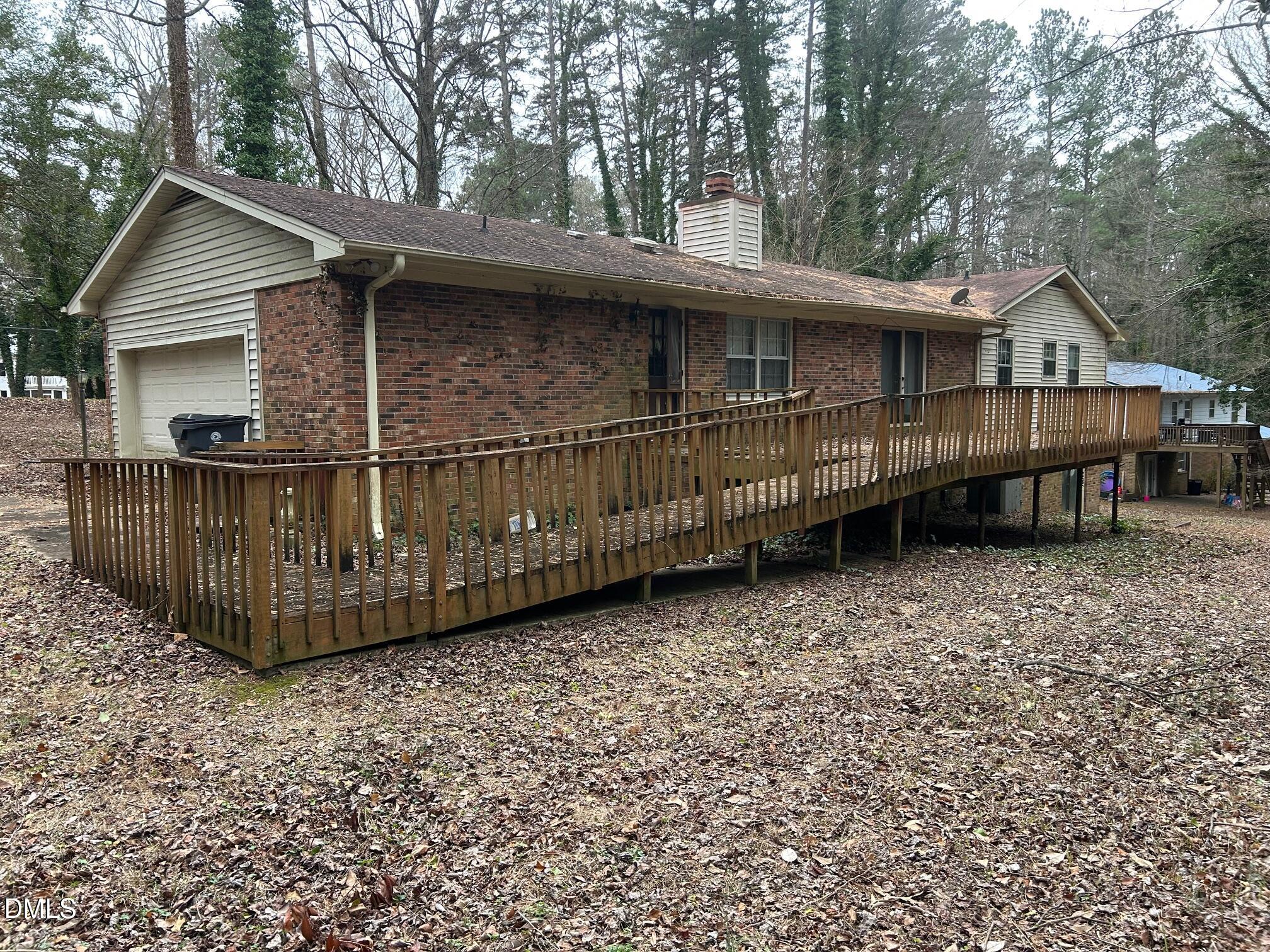 2912 Oxford Road Henderson, NC 27536 - Photo 5 of 25 a view of a house with wooden deck and trees in the background