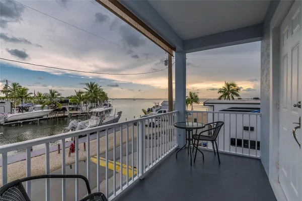 a view of a balcony with table and chairs and wooden floor