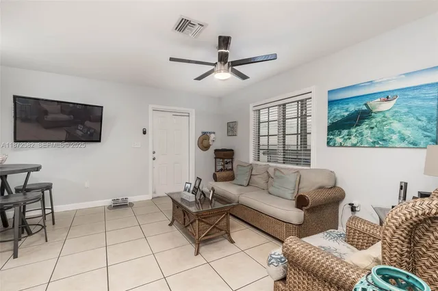 a kitchen with stainless steel appliances kitchen island granite countertop a refrigerator a stove a sink a dining table and chairs with wooden floor