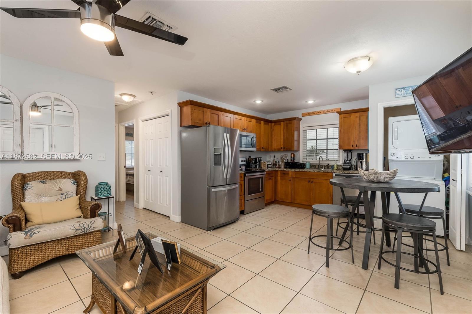 325 Calusa Street, Unit 320 Key Largo, FL 33037 - Photo 20 of 52 a kitchen with stainless steel appliances kitchen island granite countertop a refrigerator a stove a sink a dining table and chairs with wooden floor