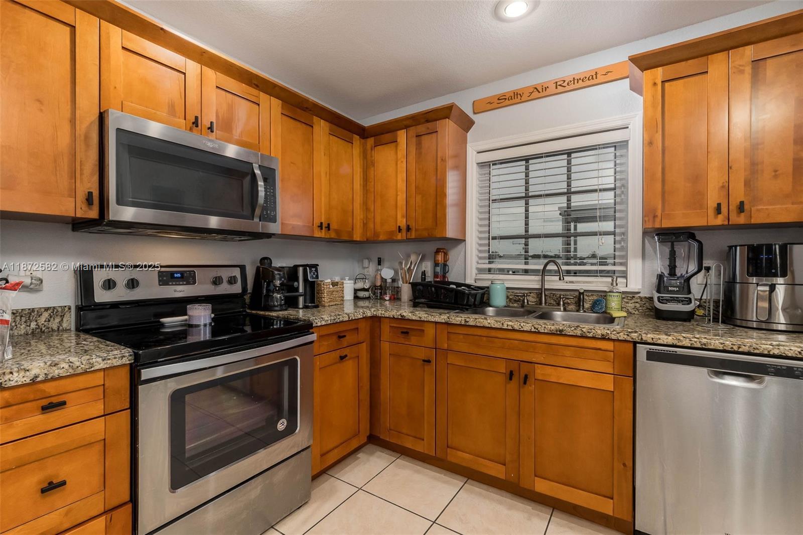 325 Calusa Street, Unit 320 Key Largo, FL 33037 - Photo 21 of 52 a kitchen with stainless steel appliances granite countertop a stove sink microwave and cabinets