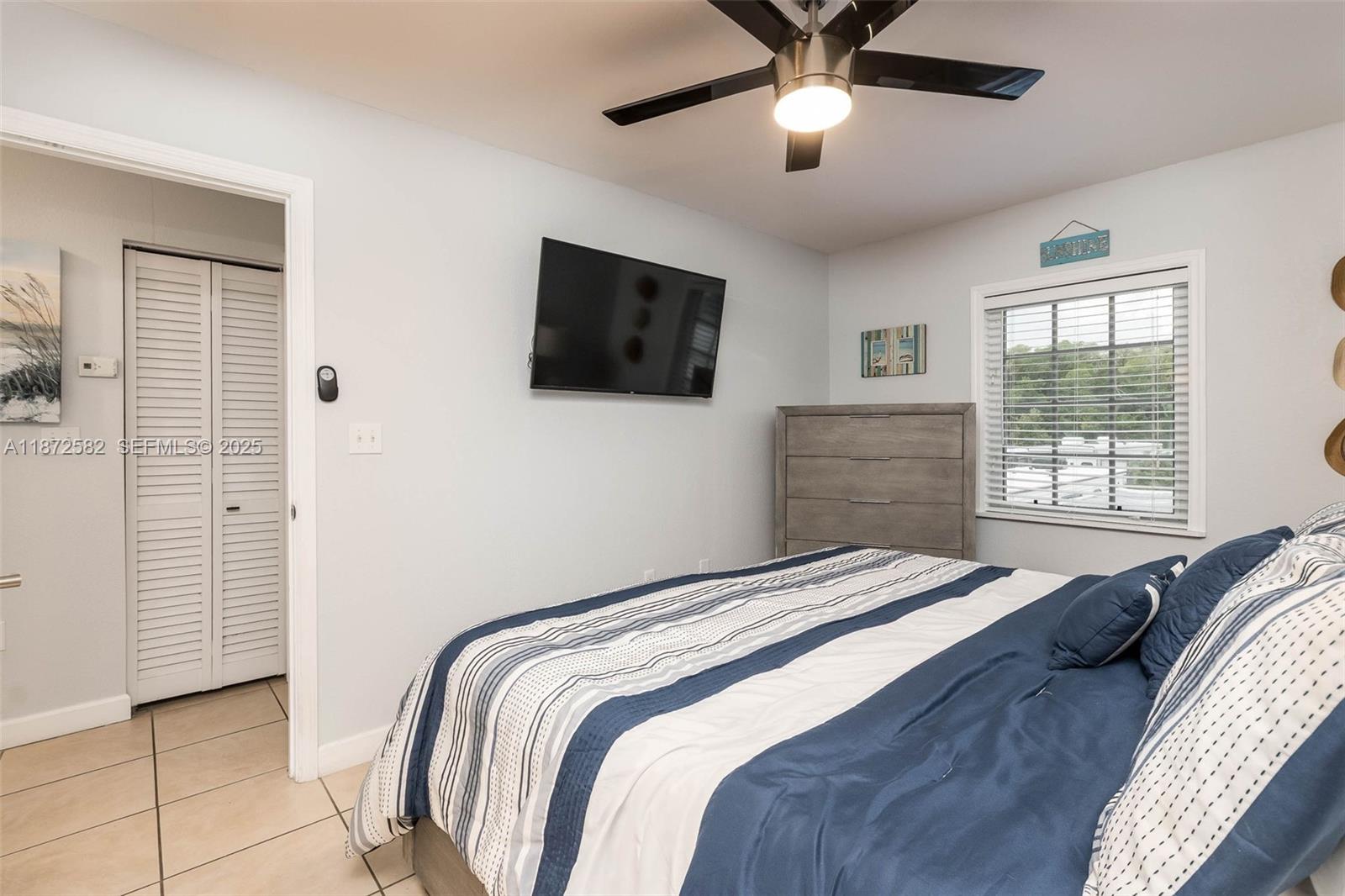 325 Calusa Street, Unit 320 Key Largo, FL 33037 - Photo 27 of 52 a bedroom with a bed and a flat screen tv