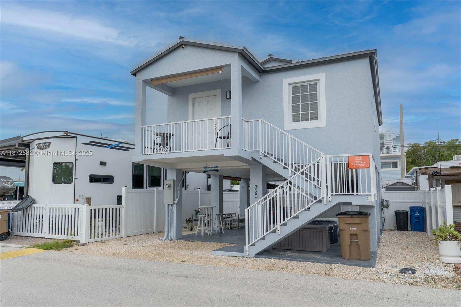325 Calusa Street, Unit 320 Key Largo, FL 33037 - Photo 3 of 52 a view of a white house with large windows and a small yard