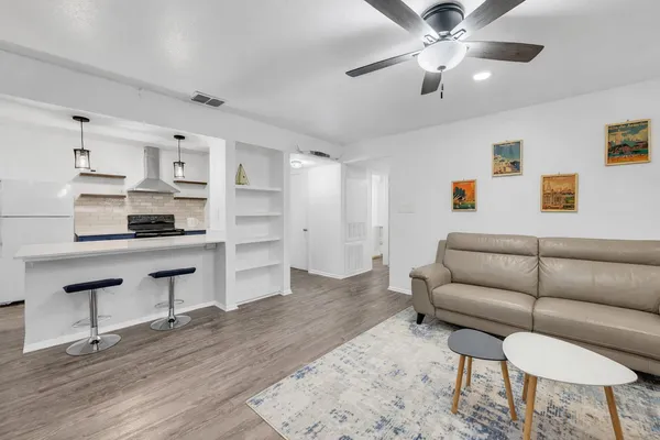 a living room with furniture and a wooden floor