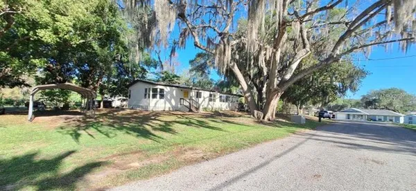a view of a house with a yard and pathway