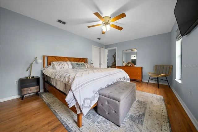a bedroom with a bed a couch and a flat tv screen on a dresser