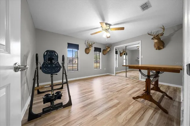 a view of a room with gym equipment and wooden floor