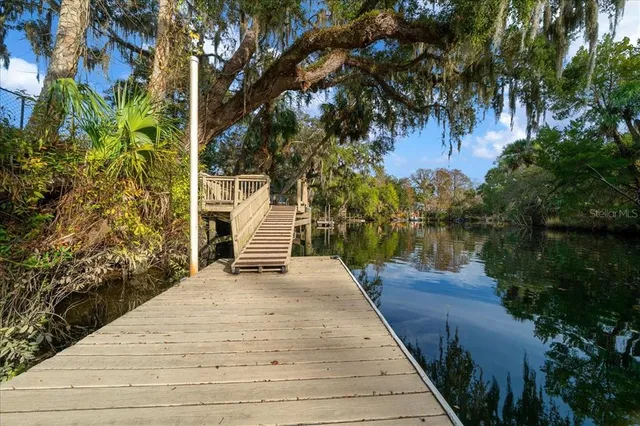 an aerial view of residential house with outdoor space and trees all around