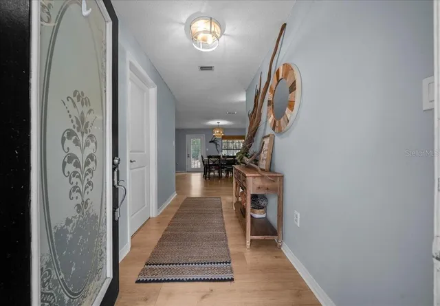 a view of entryway and hall with wooden floor