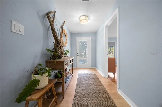 a hallway with table and a potted plant