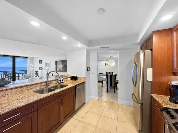 a kitchen with stainless steel appliances granite countertop a sink refrigerator and cabinets
