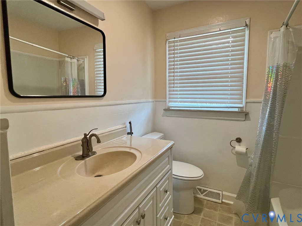 3911 Sunburst Road Henrico, VA 23294 - Photo 16 of 27 a bathroom with a sink a toilet and mirror