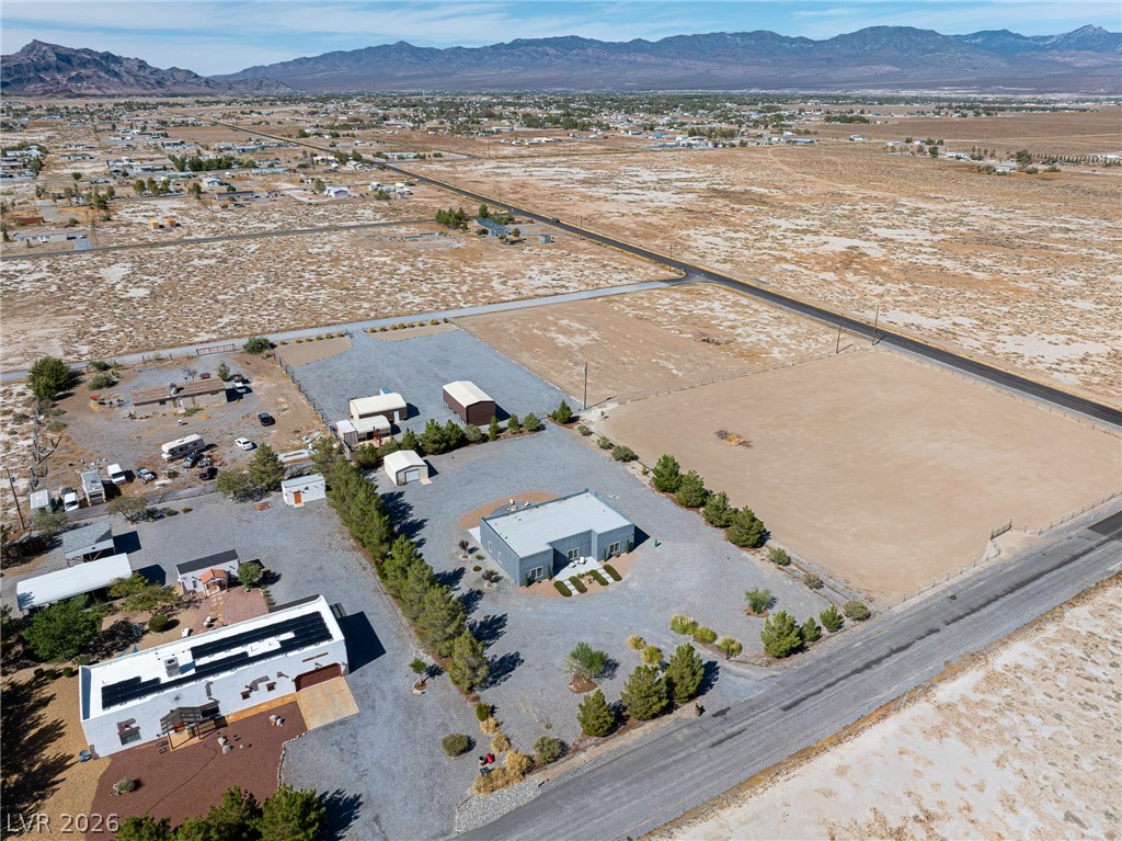 4080 Magnet Road Pahrump, NV 89048 - Photo 27 of 28 Panoramic mountain backdrops frame this extensive desert lot featuring multiple structures and clear boundary lines.