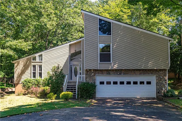 a front view of house with yard and trees around