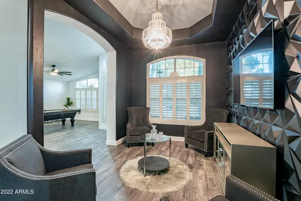 a living room with furniture kitchen view and large windows