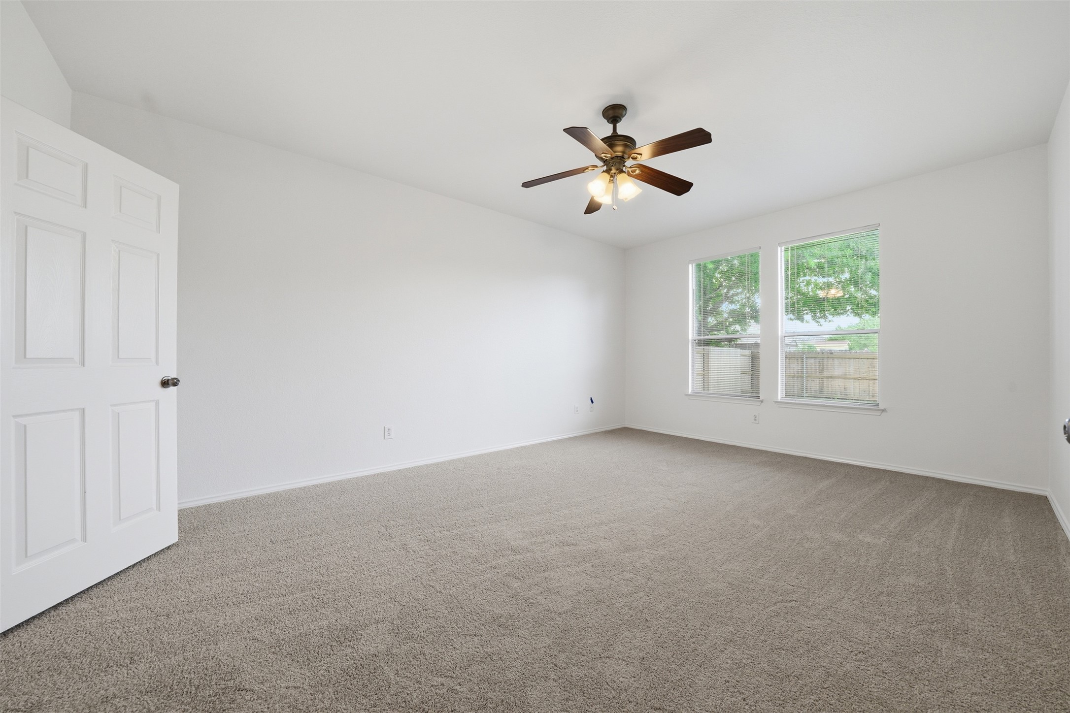 118 Invierno Street Kyle, TX 78640 - Photo 16 of 37 A spacious, naturally illuminated room features plush carpeting and a modern ceiling fan.