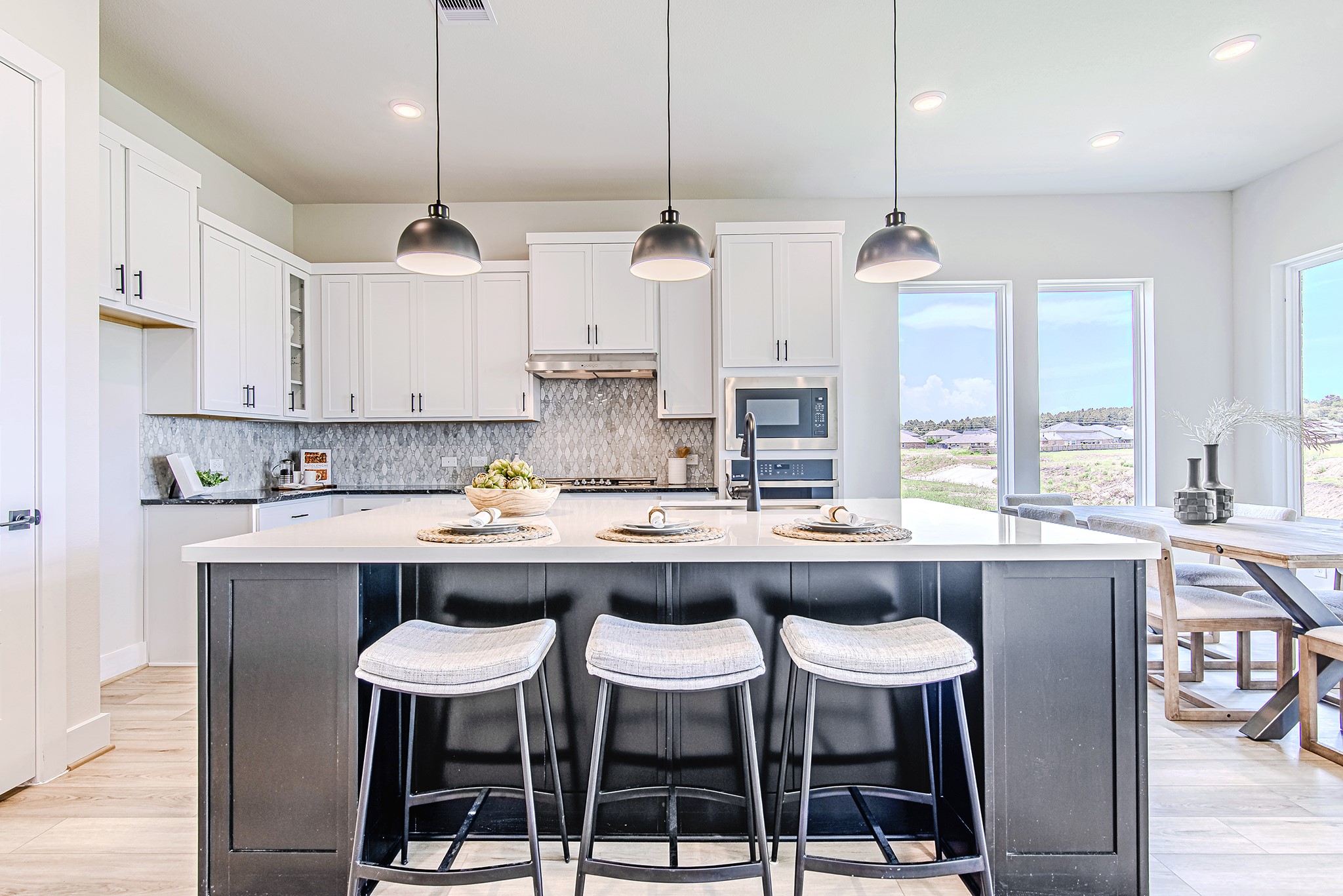 141 Peninsula Point Drive Montgomery, TX 77356 - Photo 9 of 47 Gather in a chef’s kitchen that stuns with quartz countertops, white shaker cabinetry, and breathtaking views from the adjacent dining space.