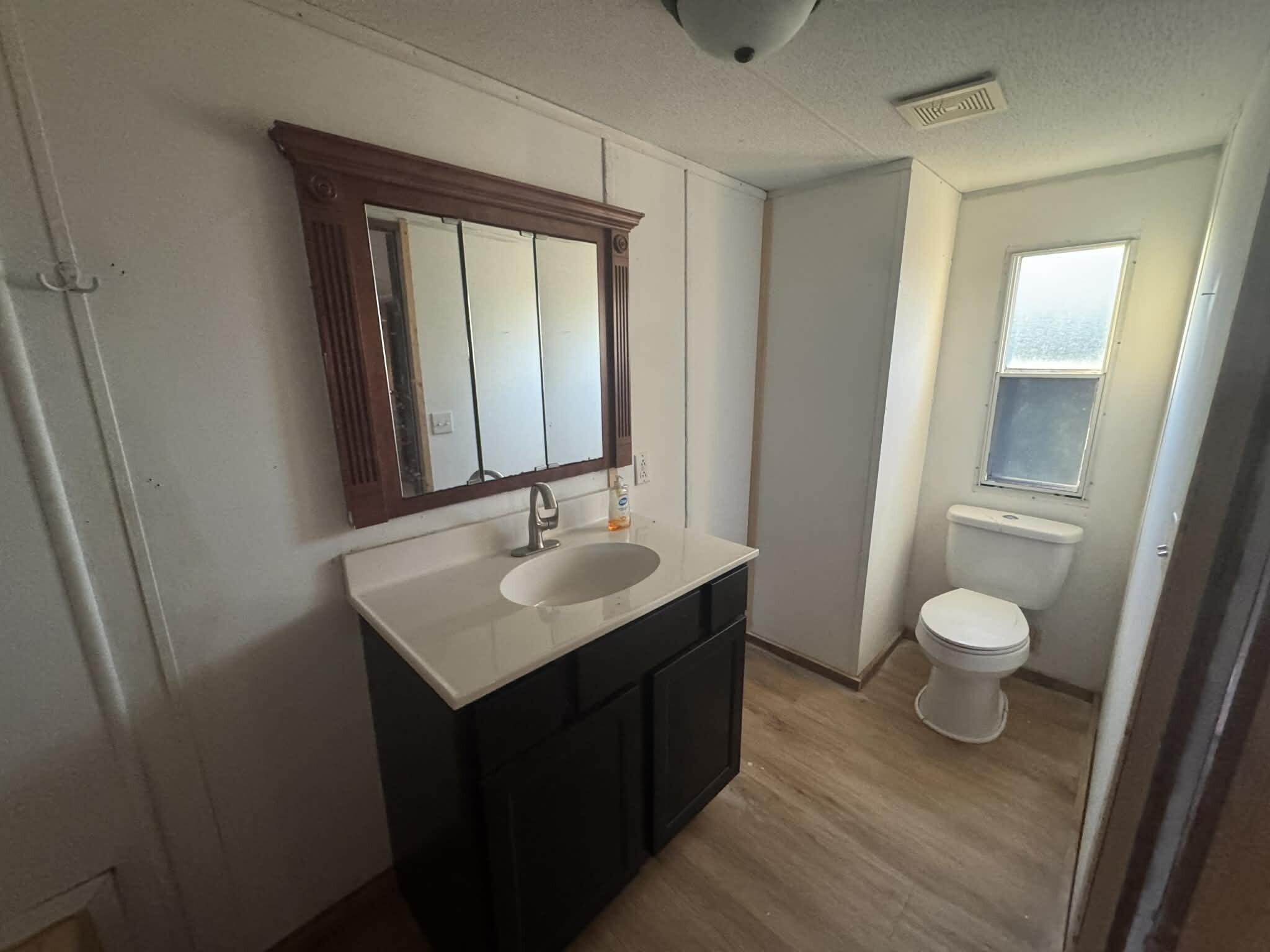 1893 Mathews Road Westville, FL 32464 - Photo 11 of 11 a bathroom with a toilet a sink and a mirror
