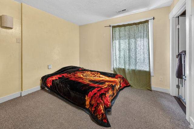 730 East 200 North Logan, UT 84321 - Photo 12 of 28 Carpeted room featuring a window with a curtain rod, baseboard trim, and a wall-mounted light fixture