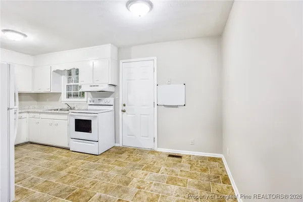 a kitchen with a stove a sink and a refrigerator