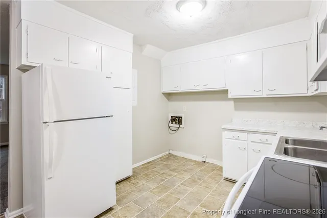 a view of a kitchen with sink and refrigerator