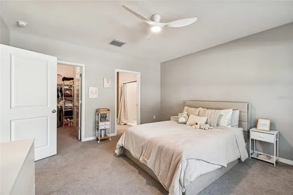 a bedroom with a bed and a refrigerator