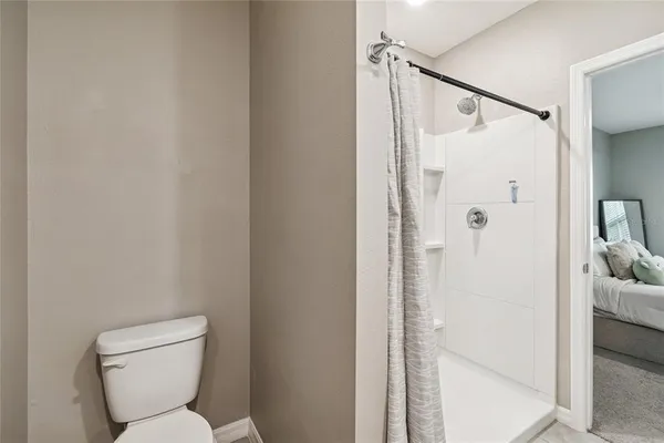 a bathroom with a toilet and a shower