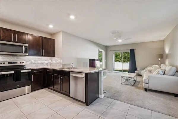 a kitchen with stainless steel appliances granite countertop a stove top oven a sink dishwasher and a refrigerator
