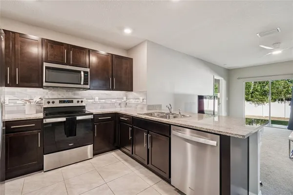 a kitchen with stainless steel appliances granite countertop a sink and stove top oven