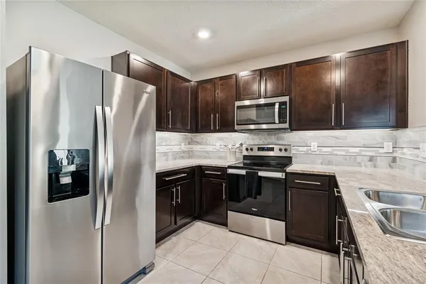 a kitchen with granite countertop stainless steel appliances and refrigerator