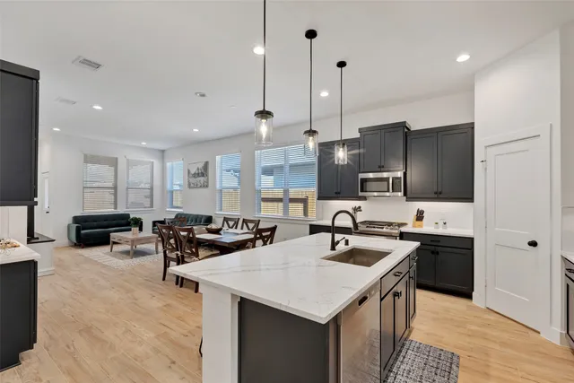 a kitchen with stainless steel appliances granite countertop a sink a stove and a refrigerator