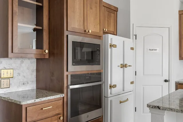 a kitchen with granite countertop a refrigerator and a sink