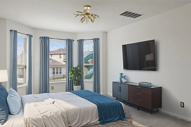 a bedroom with a bed and a flat screen tv