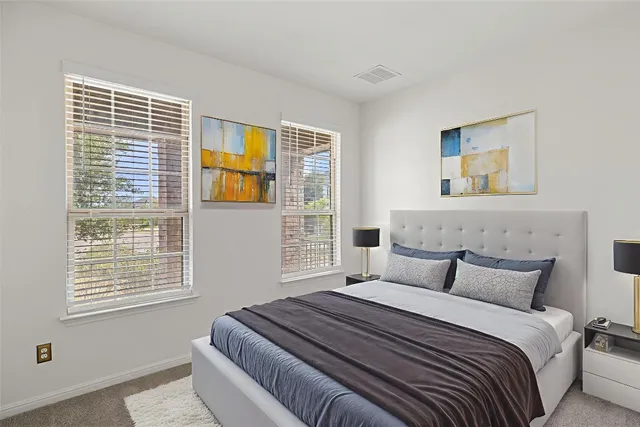 a bedroom with a bed and a painting on the wall