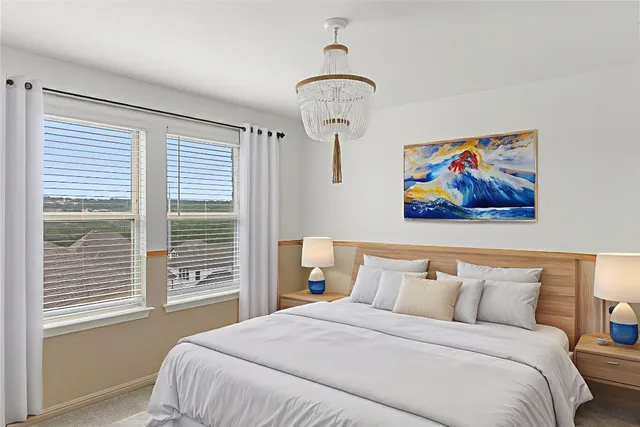 a bedroom with bed and a painting on the wall