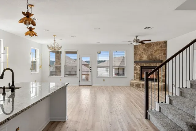 a living room with couches with wooden floor and chandelier