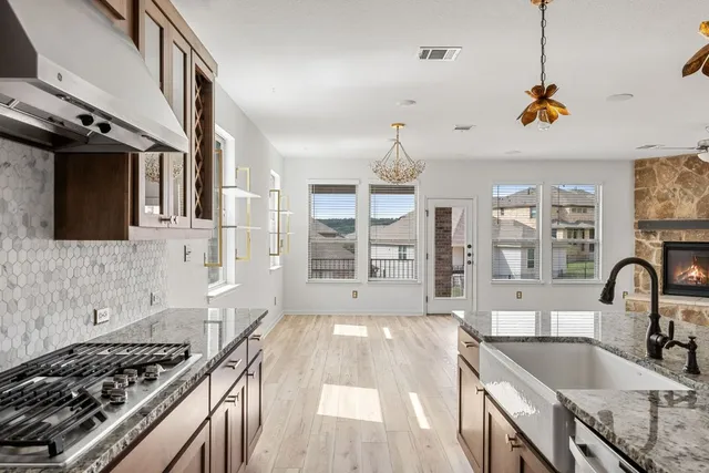a kitchen with stainless steel appliances granite countertop a sink stove and cabinets