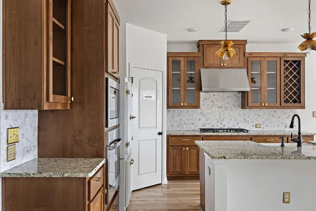a kitchen with stainless steel appliances granite countertop a sink a stove and a refrigerator