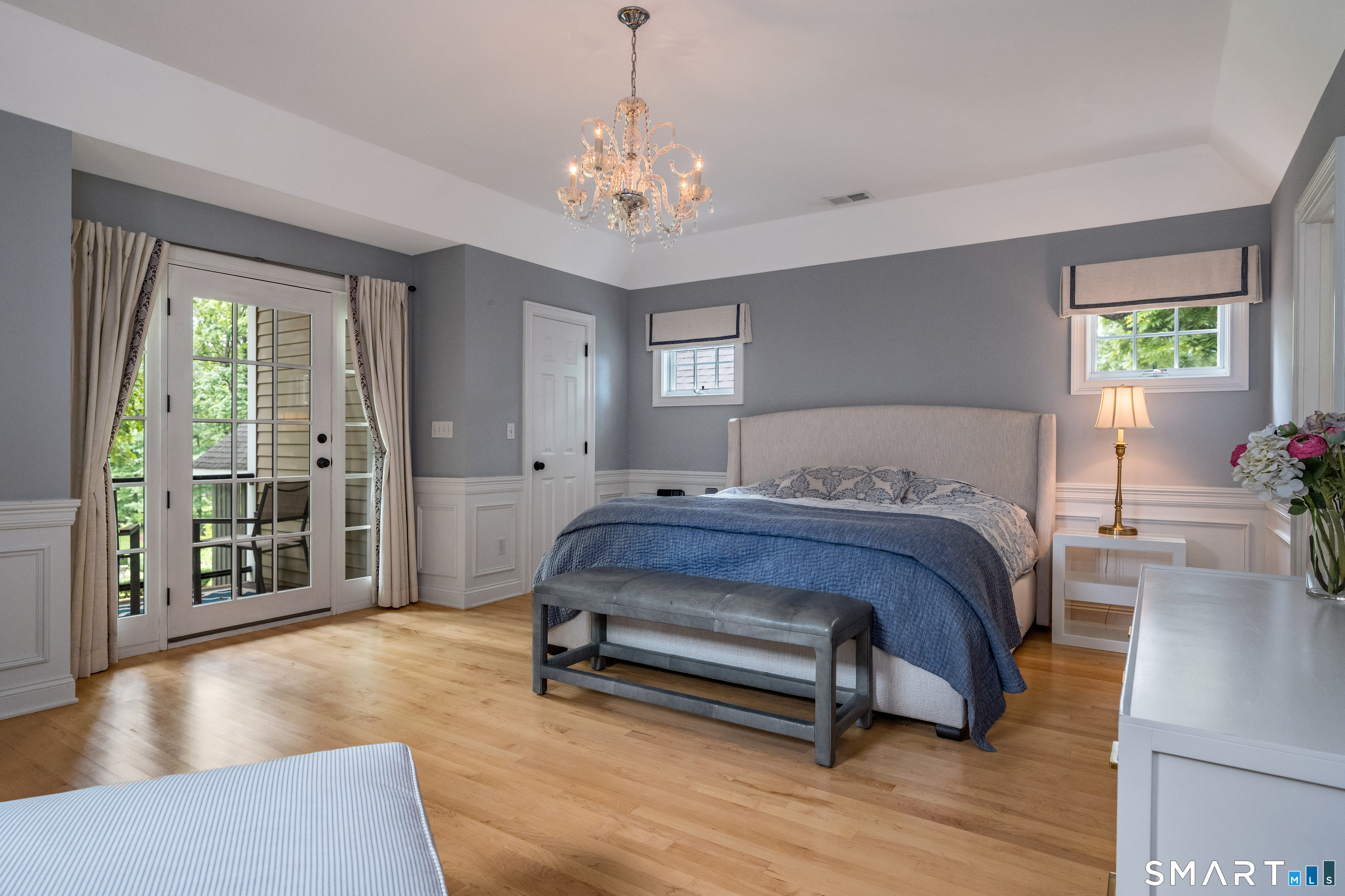 63 Broad Street Guilford, CT 06437 - Photo 17 of 40 a spacious bedroom with a bed and a chandelier