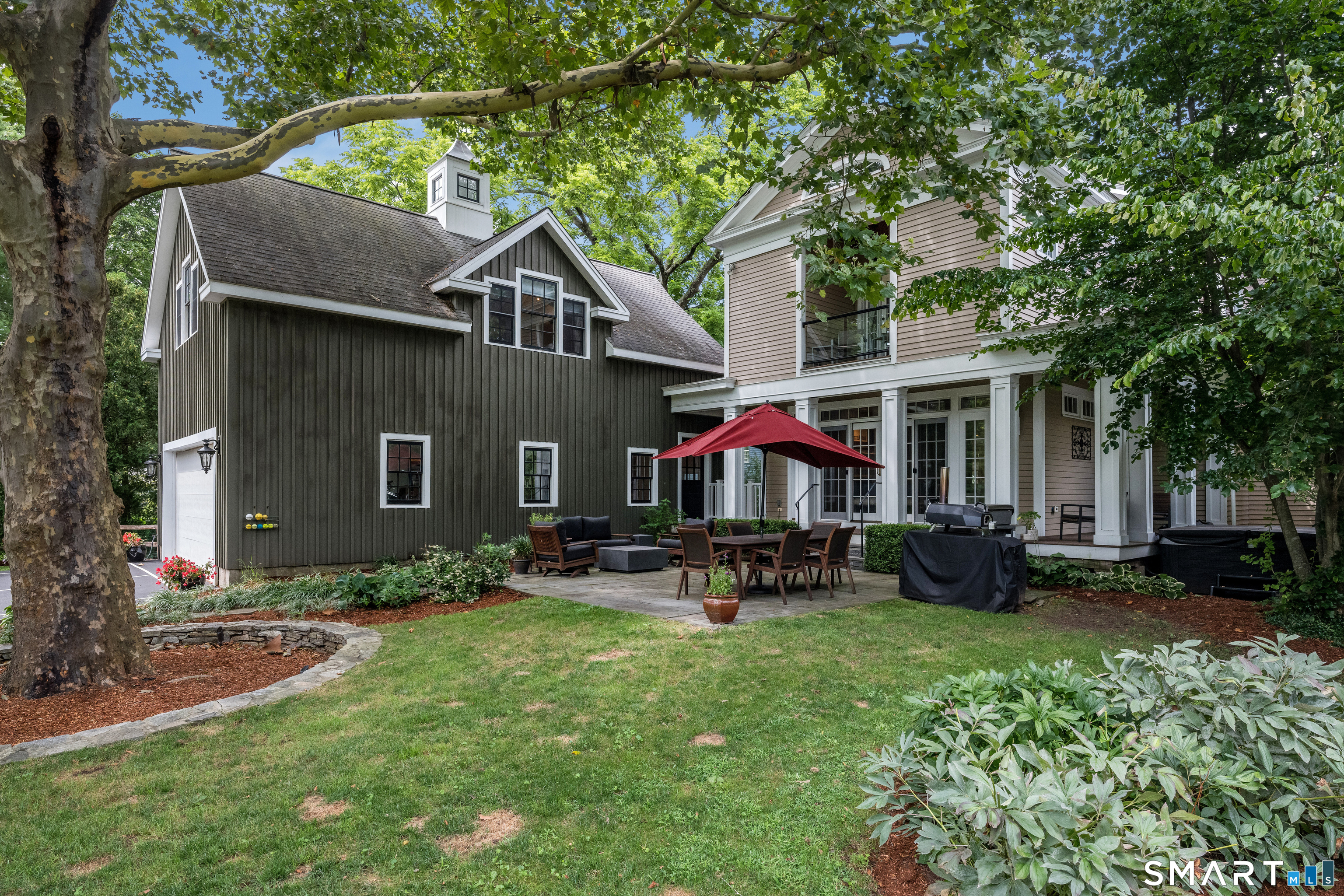 63 Broad Street Guilford, CT 06437 - Photo 31 of 40 a view of a yard with table and chairs under an umbrella