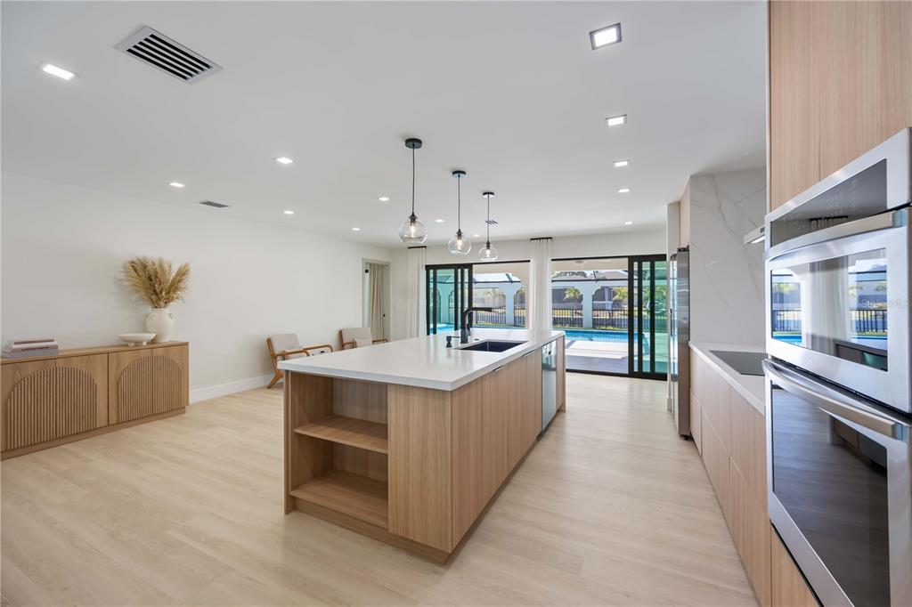 105 Sinclair Street Southeast Port Charlotte, FL 33952 - Photo 16 of 69 a large kitchen with stainless steel appliances a large counter top a stove and a refrigerator