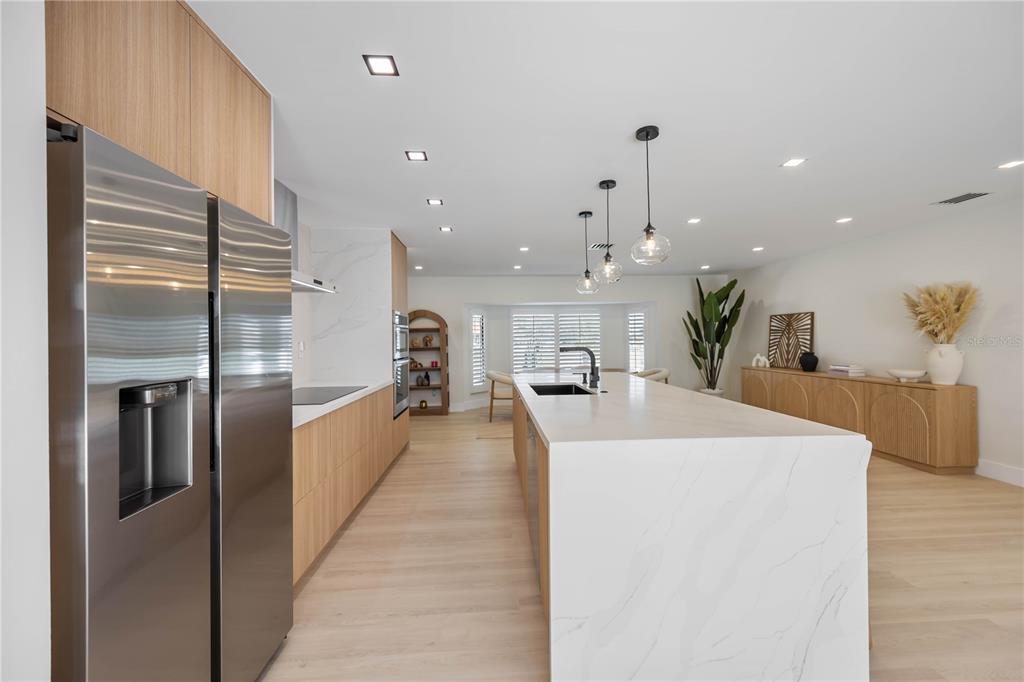 105 Sinclair Street Southeast Port Charlotte, FL 33952 - Photo 19 of 69 a large kitchen with stainless steel appliances kitchen island a large counter top a refrigerator and a sink