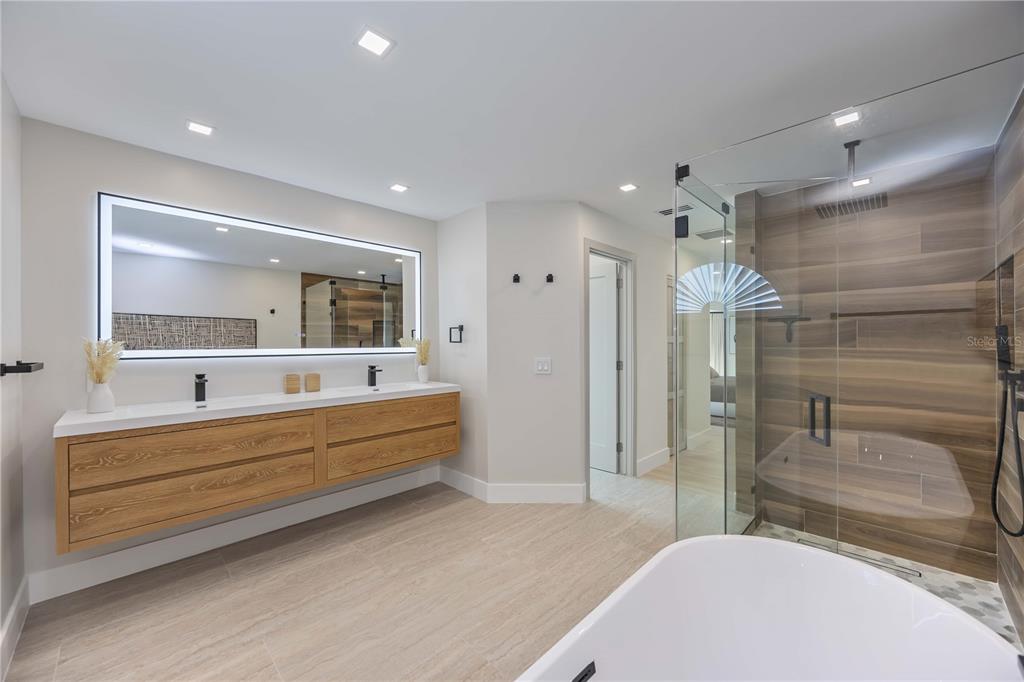 105 Sinclair Street Southeast Port Charlotte, FL 33952 - Photo 28 of 69 a bathroom with a tub a double vanity sink and mirror